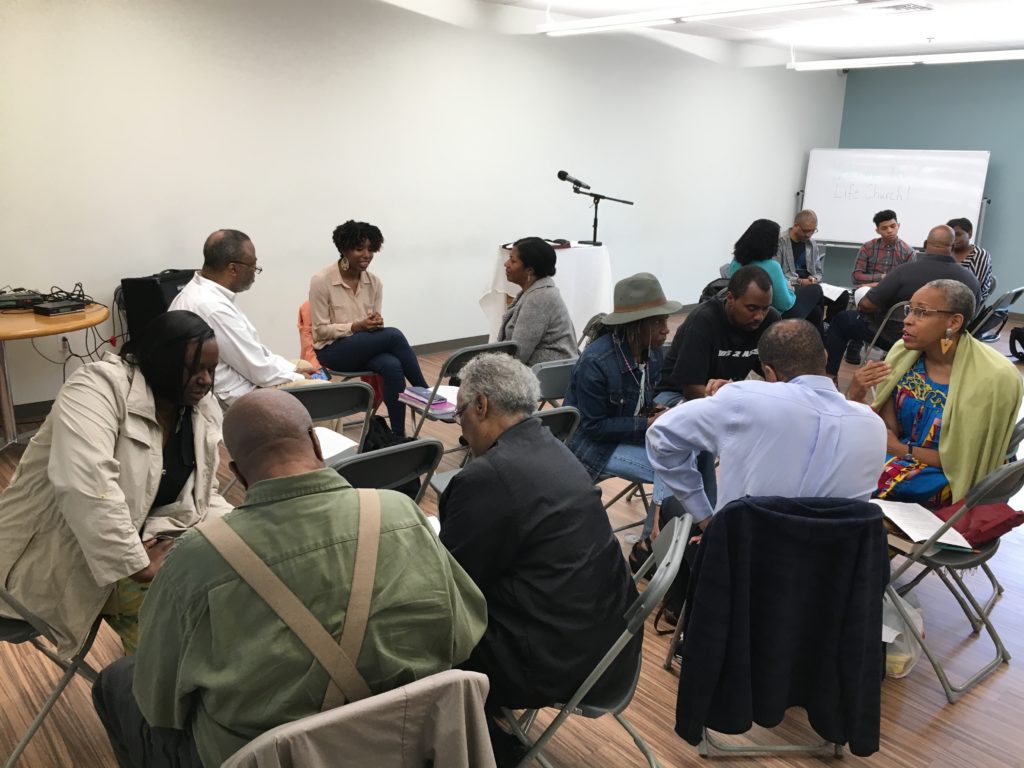 Members of the congregation sitting in groups of 3-5 having a dicussion 